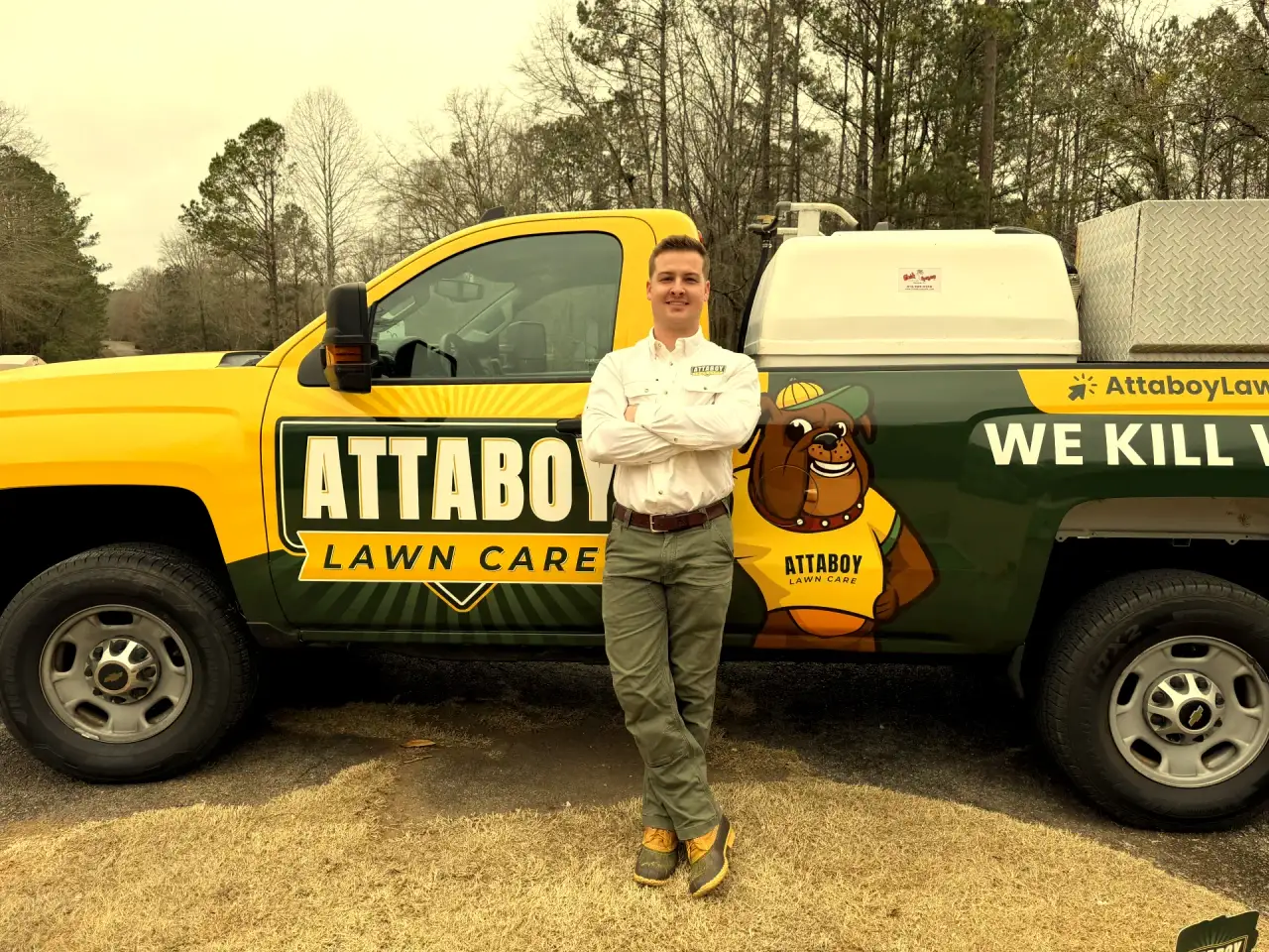 Attaboy Lawn Care owner standing confidently with branded service truck