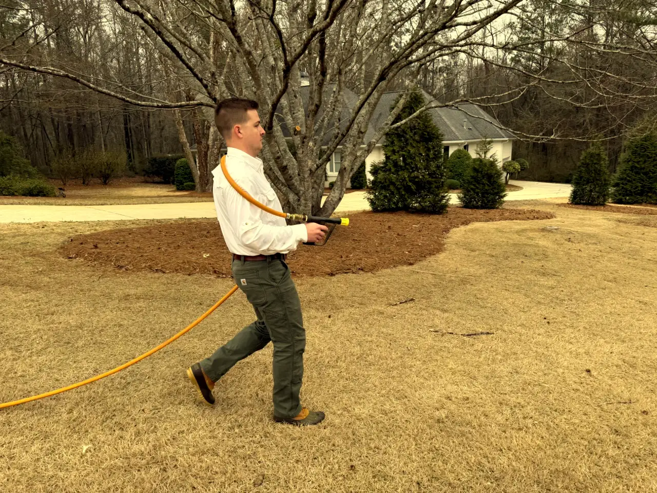 Attaboy Lawn Care technician applying fire ant control treatment